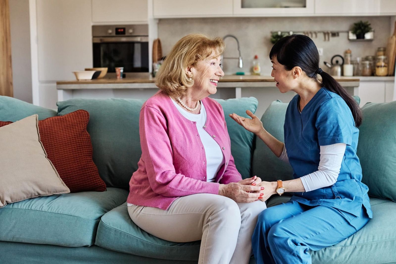 A caregiver sharing a warm conversation with a client at home