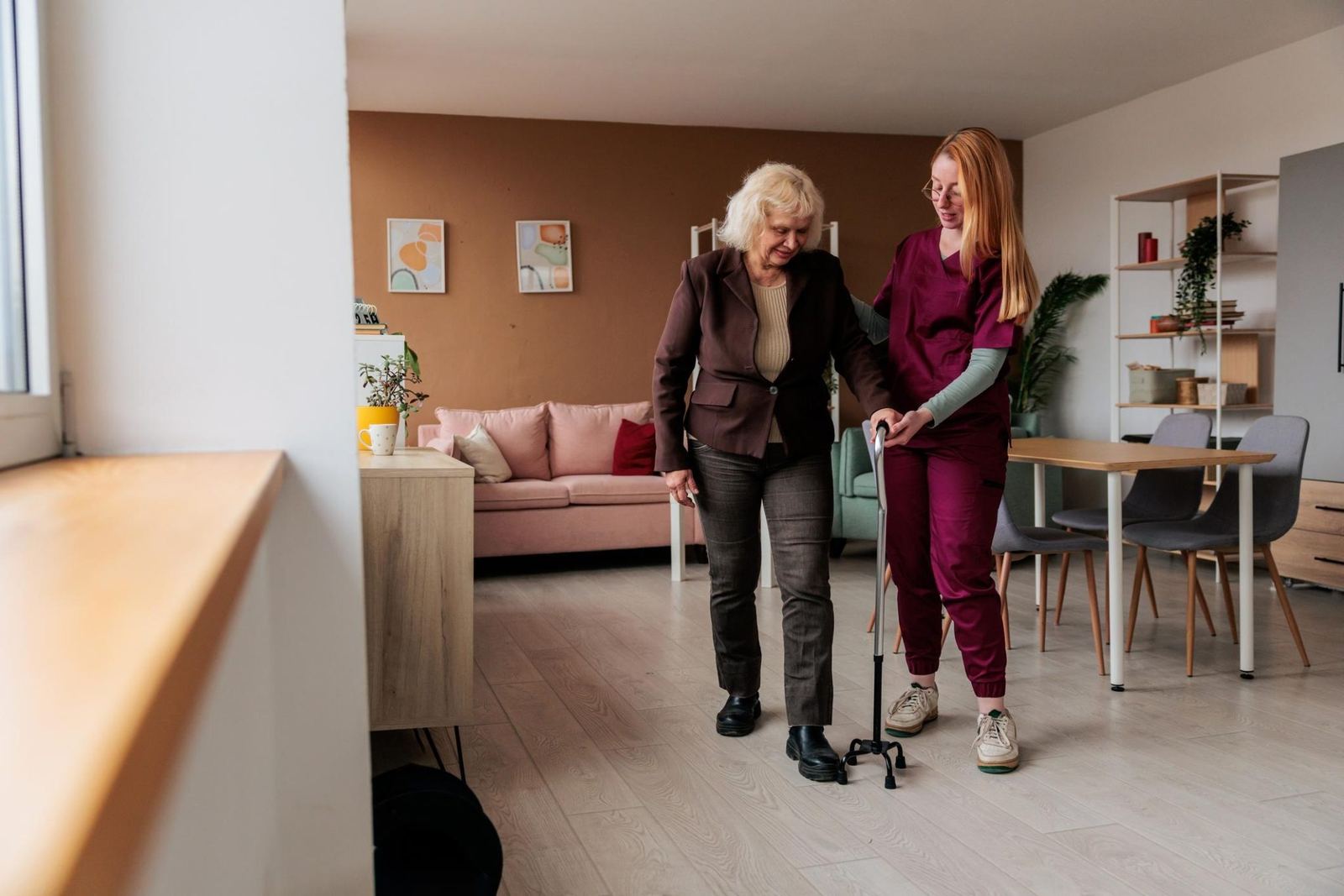 A caregiver helping a client walk safely at home